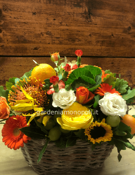 Cesto in legno con fiori recisi e frutta